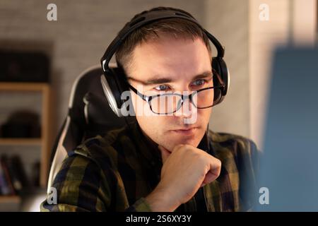 portrait of his he nice attractive focused professional guy coding programming supporting website remotely at modern work place station. the young man Stock Photo