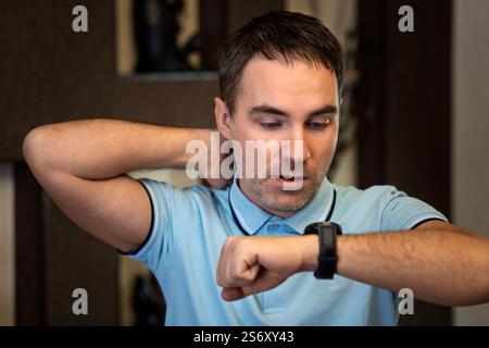 shocked businessman with hand watch. man checking time. wristwatch on male hand. the concept of being late for work, breaking deadlines in business, h Stock Photo