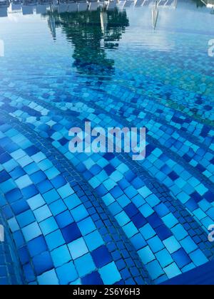 Handrail stairs to the blue pool.Pool with stairs and water. Stainless steel stairs to the pool. Stock Photo