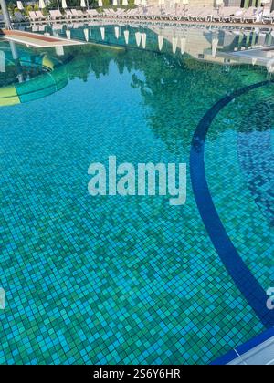 Handrail stairs to the blue pool.Pool with stairs and water. Stainless steel stairs to the pool. Stock Photo