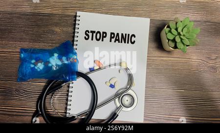Concept of Stop Panic write on book isolated on Wooden Table. Stock Photo