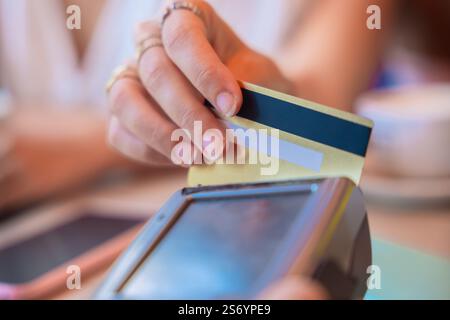 Woman Making Contactless Payment with Credit Card in a Cafe Stock Photo