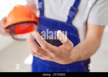 Close up of male worker suffering after job accident showing hand with bandaged finger Stock Photo