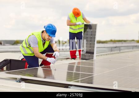 Electricians Installing, Maintaining, Or Repairing Solar Panels On Roof Stock Photo