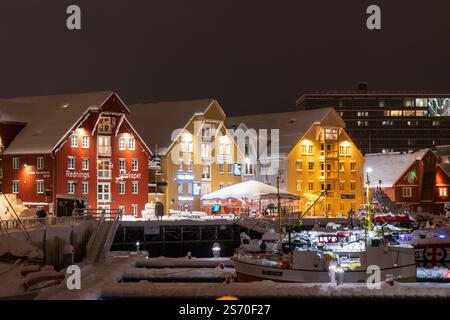 Main harbour of Tromsø at night, with typical norwegian wooden houses in red, yellow and blue. Winter snow, polar night Stock Photo