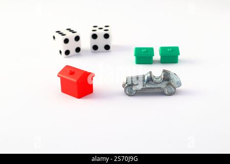 Monopoly game pieces. Car, hotel, house and dice. Close up and isolated on a white background. Stock Photo