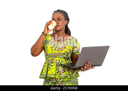 beautiful young businesswoman wearing traditional loincloth and holding laptop and drinking coffee from a cup. Stock Photo