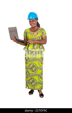 beautiful young female engineer wearing safety helmet and working on laptop while smiling. Stock Photo