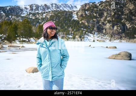 POV of African American young woman taking selfie with two hands with mobile in snowy mountains. Stock Photo