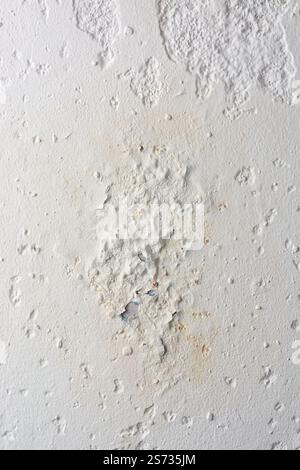 close-up section of plaster finished wall surface with damage caused by moisture, peeling or flaking off with cracks, chips and water penetrated Stock Photo