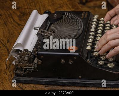 Womans hand typing on Remington portable vintage typewriter . Stock Photo