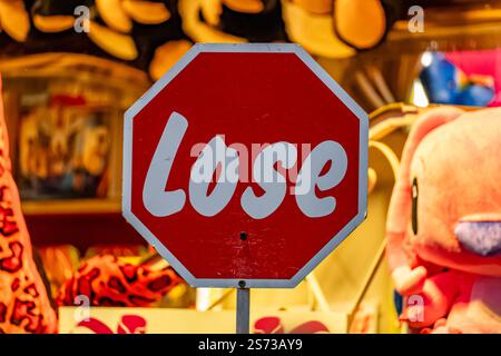 A stop sign with the word "LOSE" written on it. The sign is surrounded by stuffed animals, giving it a playful and whimsical feel Stock Photo