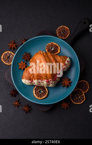 Crispy sweet red croissant with pistachio, raspberry and strawberry on a dark concrete background Stock Photo