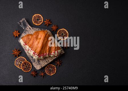 Crispy sweet red croissant with pistachio, raspberry and strawberry on a dark concrete background Stock Photo