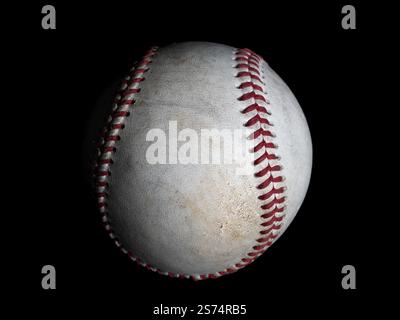 A single baseball viewed from the side, isolated on a deep black background, emphasizing its texture, stitching, and timeless design. Stock Photo