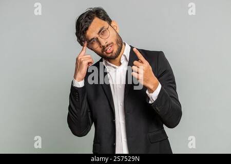 Need to think. Doubting pensive Indian businessman pondering, imagining in mind, wondering difficult solution, feeling confused, not sure about choice. Male Arabian man man isolated on gray background Stock Photo