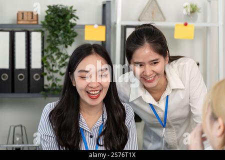 Two business professionals sharing a joyful moment while collaborating in an office Stock Photo