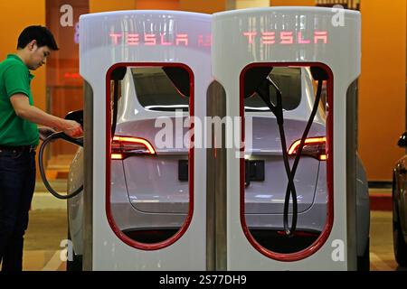 Bangkok, Thailand - February 17, 2023: Tesla electric car is charged at the brand new Tesla EV supercharger station located in Centralworld shopping. Stock Photo