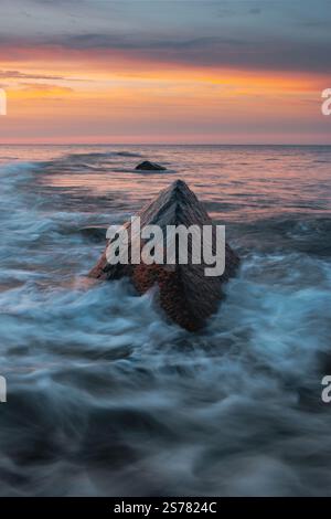 A vertical shot of waves crashing against the rocky coastline Stock ...