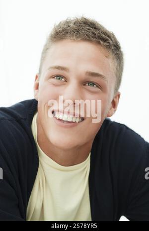 Smiling young blond man loooks up, head and shoulders portrait, Denmark, Europe Stock Photo