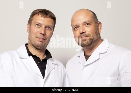 Two men in white coat smiling to the camera Stock Photo