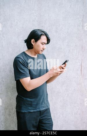 Man texting on his phone, seen from a side perspective. Stock Photo