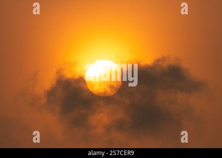 dramatic golden sunrise behind dark clouds with orange skies Stock Photo