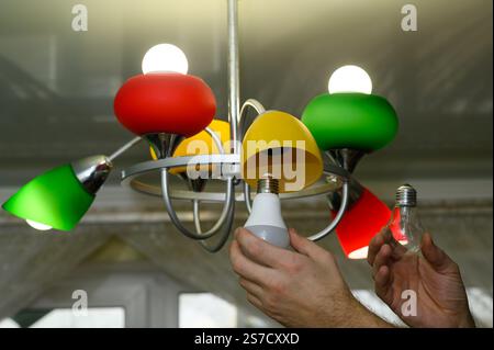 the concept of replacing an incandescent lamp with an LED one. Stock Photo
