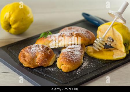 Pastries. Sweet buns with quince and honey filling, on a wooden table . Stock Photo