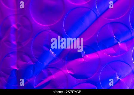 Abstract close up of crumpled bubble wrap with pink and blue light Stock Photo