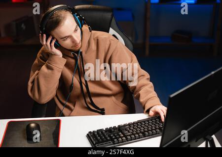 Bored young hipster gamer pining while playing boring online video game, top view Stock Photo