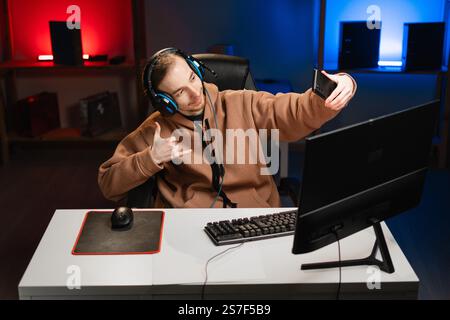 Male hipster taking selfie photo while playing video game on computer at home Stock Photo