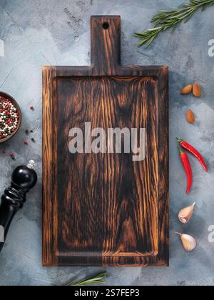 Top view of empty cutting board on table surrounded by various spices, template for designer Stock Photo