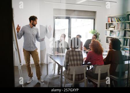 Diverse employees gathered in the office having fun during brainstorming while discussing new ideas Stock Photo