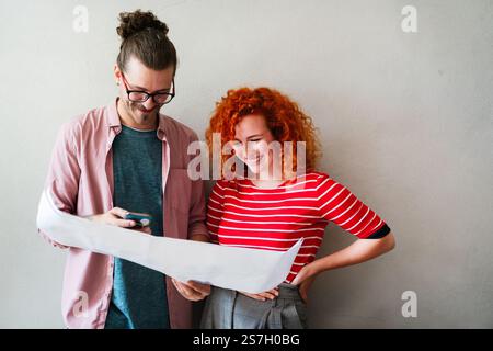 Happy businesspeople laughing while collaborating on a new project in an office. Business startup. Stock Photo