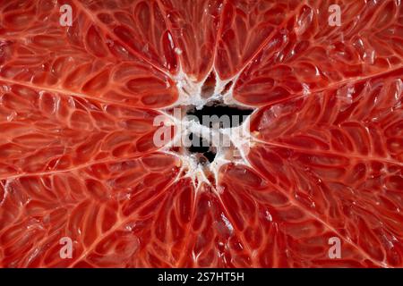 Juicy red grapefruit slice on background . Texture fresh citrus fruit, close up, healthy sweet food. Macro photography Stock Photo