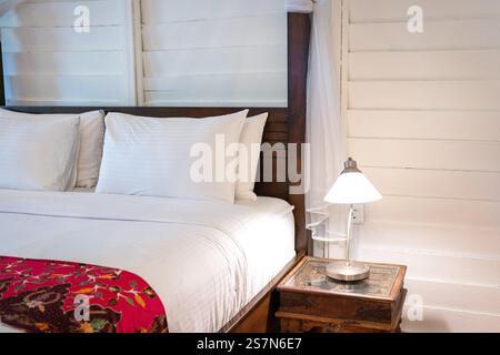 Bedside with side table and lamp on top of it. Cosy living. Stock Photo