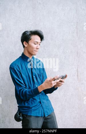 Young man engrossed in playing a mobile game, focused expression. Stock Photo