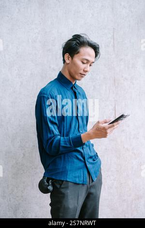 Young man focused on using a mobile app on his smartphone. Stock Photo