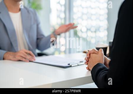 A close-up image of an Asian woman during a job interview with a male CEO in an office. job interview, recruitment, career, occupation Stock Photo