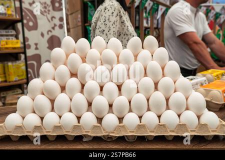 Chicken eggs with while eggshell in a cardboard packaging. Heap of chicken eggs from village. Tasty breakfast. Eggs on the counter. Stock Photo