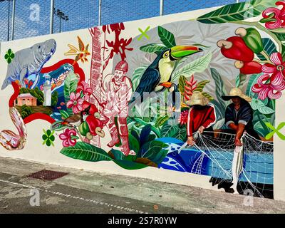 A vibrant and detailed mural showcasing a blend of exotic wildlife, tropical flora, and local traditions. The artwork features toucans, a manatee, tro Stock Photo