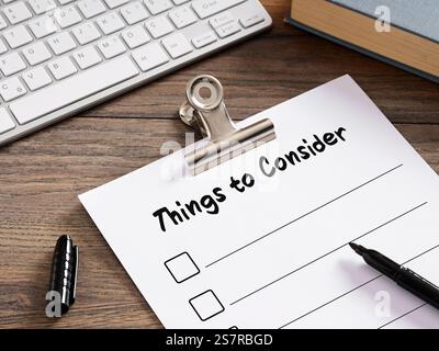 Checklist of things to consider lying on office desk with computer keyboard and book, planning development strategy Stock Photo