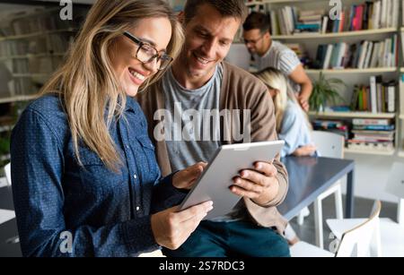 Two young businesspeople using a digital tablet while standing in a boardroom. Stock Photo