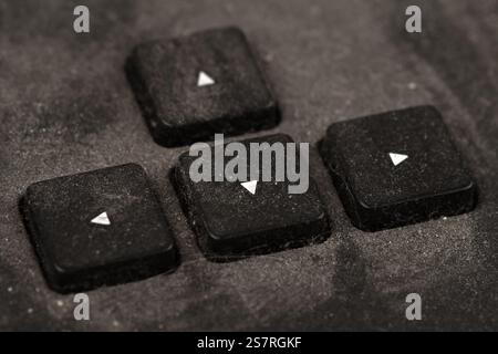 front view closeup of old black keyboard with arrow keys covered in dust and dirt isolated on white background Stock Photo