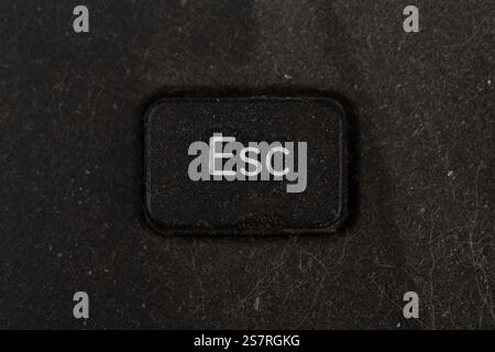 front view closeup of escape key on an old black keyboard covered in dust and dirt isolated on white background Stock Photo