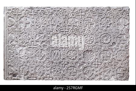 A closeup view of a carved stone tile featuring intricate floral and geometric patterns Stock Photo