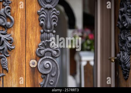 Architectural detail.  The oak double doors which are decorated with unique baroque carvings. An open old oak wood door background with decor. Stock Photo