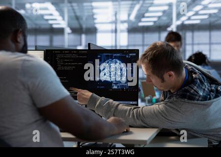 Team of admins does data center workplace automation using AI and machine learning tools. Teamworking colleagues integrating artificial intelligence driven automation in server hub facility operations Stock Photo