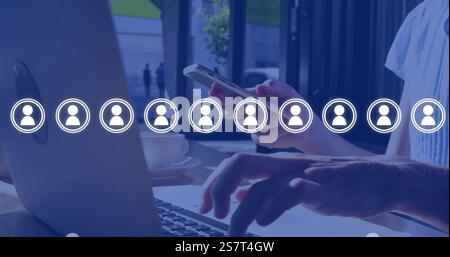 Image of network of people icons over caucasian businesswoman using smartphone and laptop Stock Photo